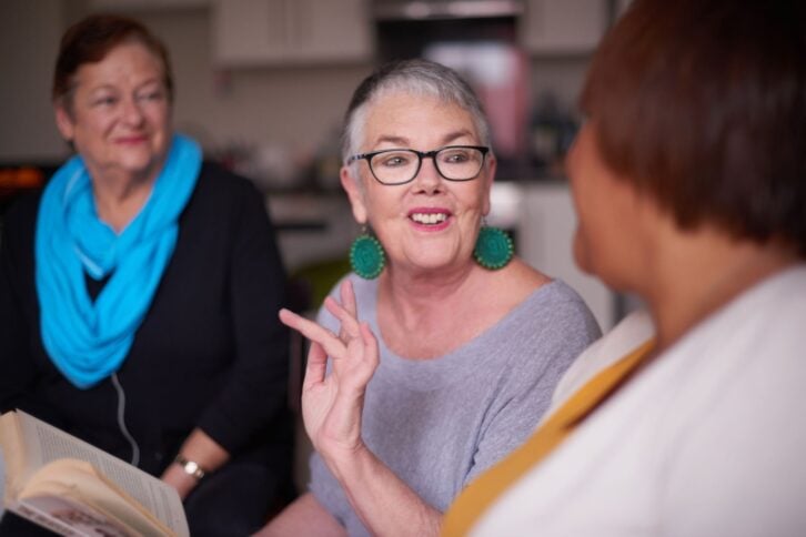 Shot of senior women reading a book together and having a discussion about it