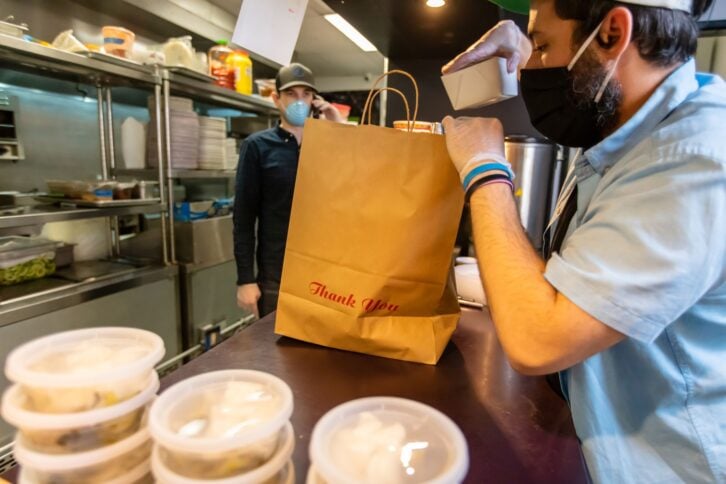 A restaurant adapts to the Covid-19 pandemic and stay at home orders by pivoting to take out and delivery.