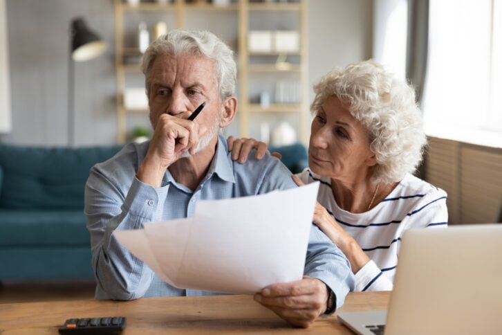 Compassionate elderly woman supporting upset stressed mature husband, received bad news banking letter. Unhappy depressed family married couple having financial trouble, got house eviction notice.