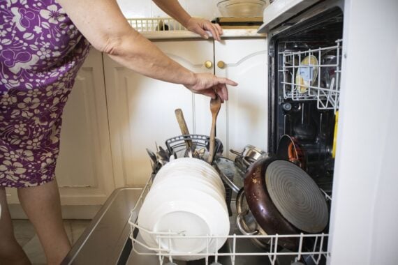 Woman using dishwasher in the kitchen