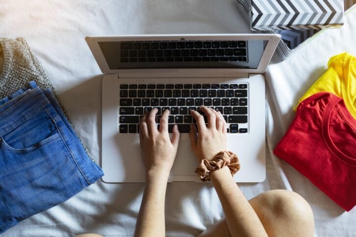 Top view of a woman selling clothes with her computer at home