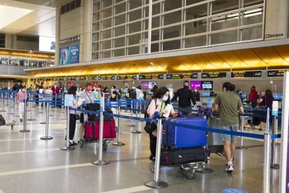 Travelers with luggage at LAX departure hall with face masks