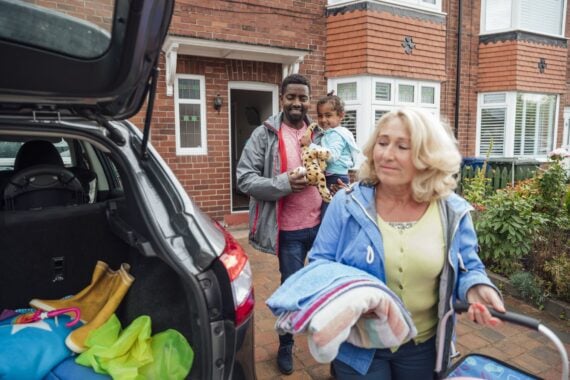 Three generation family leaving their house heading to the car to go on a road trip. Taken during the Covid 19 pandemic.