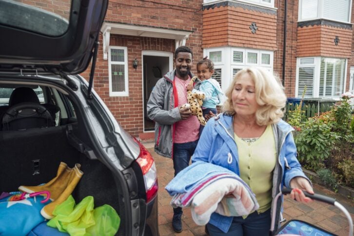 Three generation family leaving their house heading to the car to go on a road trip. Taken during the Covid 19 pandemic.