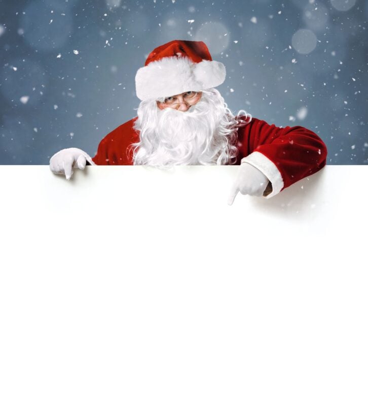 Happy Santa Claus pointing in blank white advertisement banner with copy space