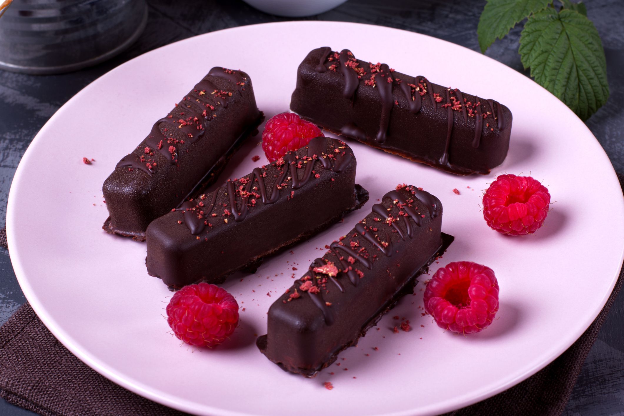 Chocolate glazed cottage cheese bites and raspberry on the ceramic plate. Soviet and Russian cuisine dessert