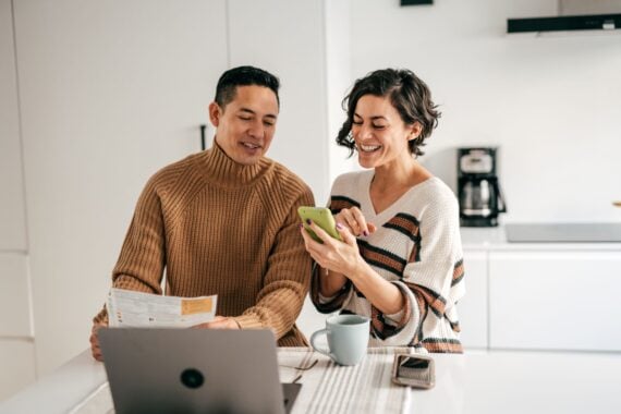 Online banking for family budget - couple in the kitchen with bills