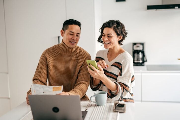 Online banking for family budget - couple in the kitchen with bills