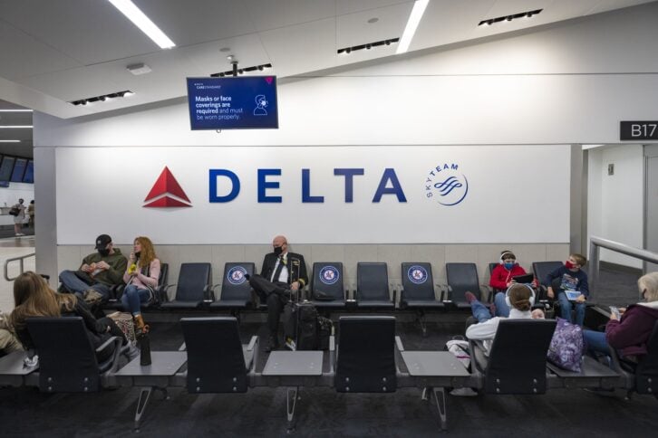Atlanta, USA - January 23, 2021:  Passengers and a pilot wear face masks because of Covid-19 as they wait at a Delta Air Lines gate at Hartsfield-Jackson Atlanta International Airport.