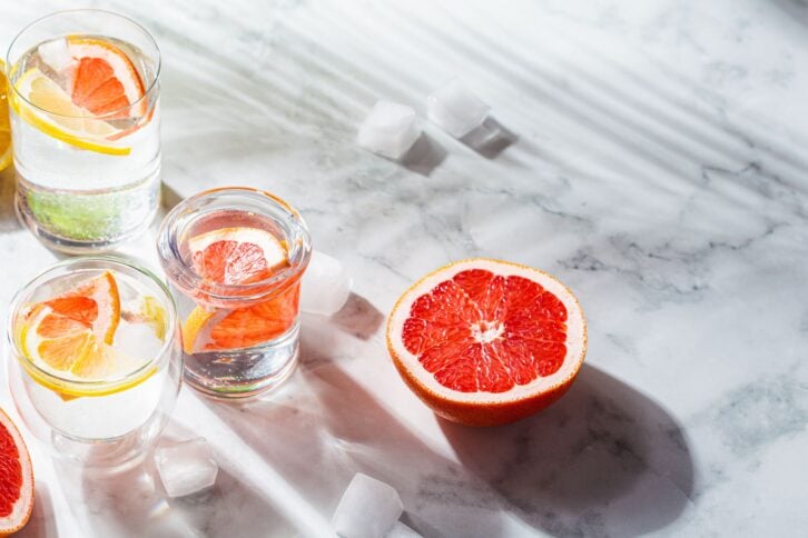 Glasses of water with grapefruit and lemon. Fresh citrus sassy water.