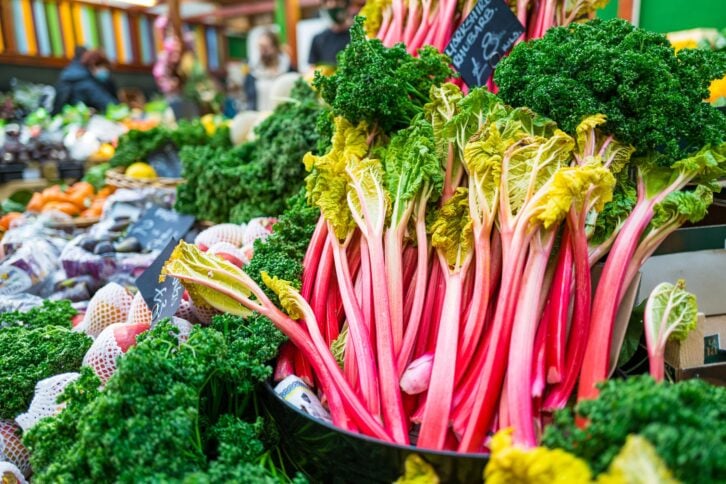 Sticks of fresh rhubarb for sale at a fruit and vegetable market.