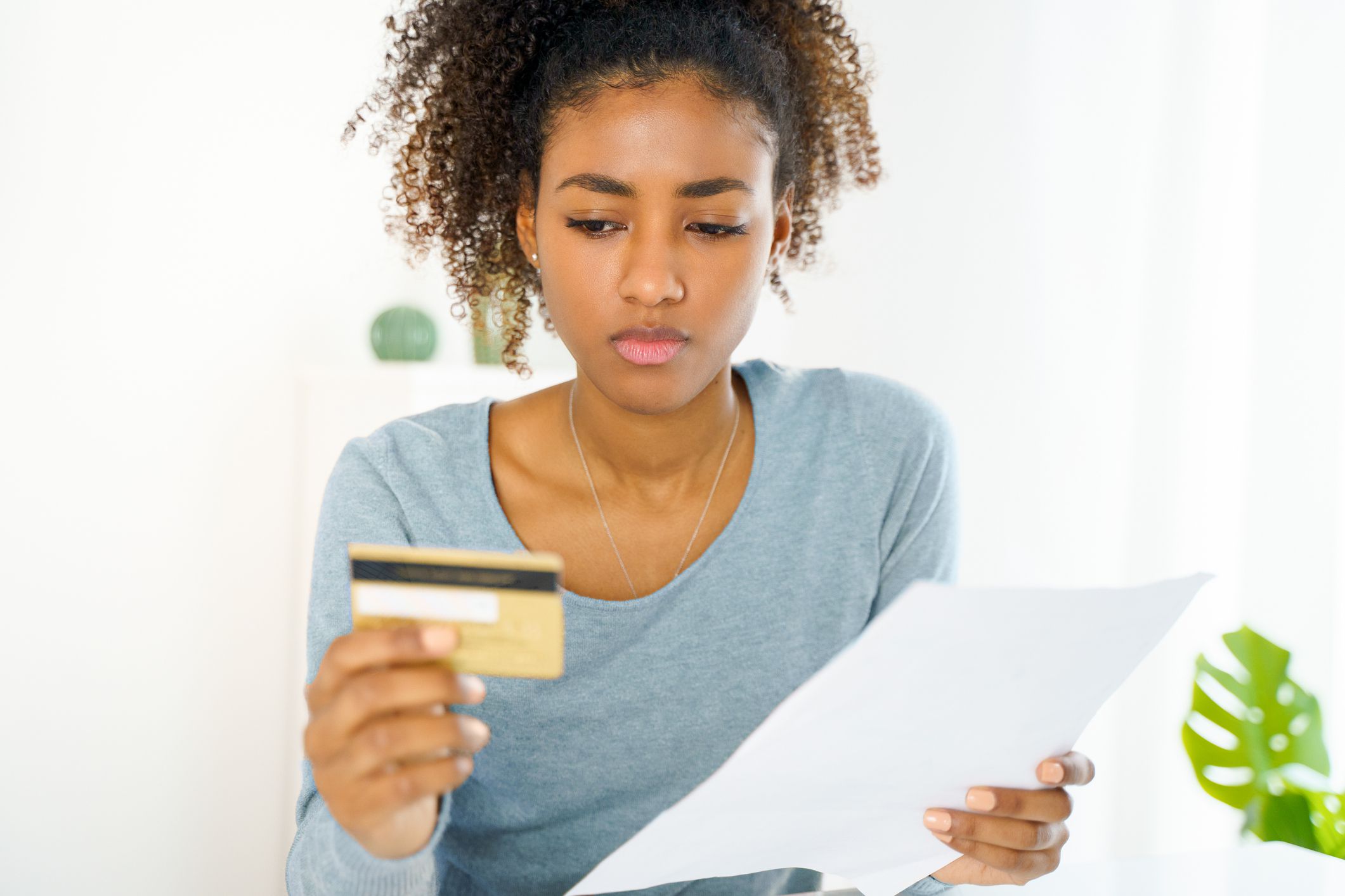 Unhappy black woman feel worried checking credit card expenses