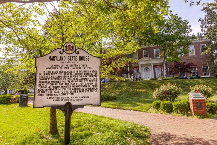 Annapolis, MD, USA 05-02-2021: Historical Maryland State Capitol building in Annapolis, the oldest state house that is still in use. It is inside a scenic garden with people walking around in spring.
