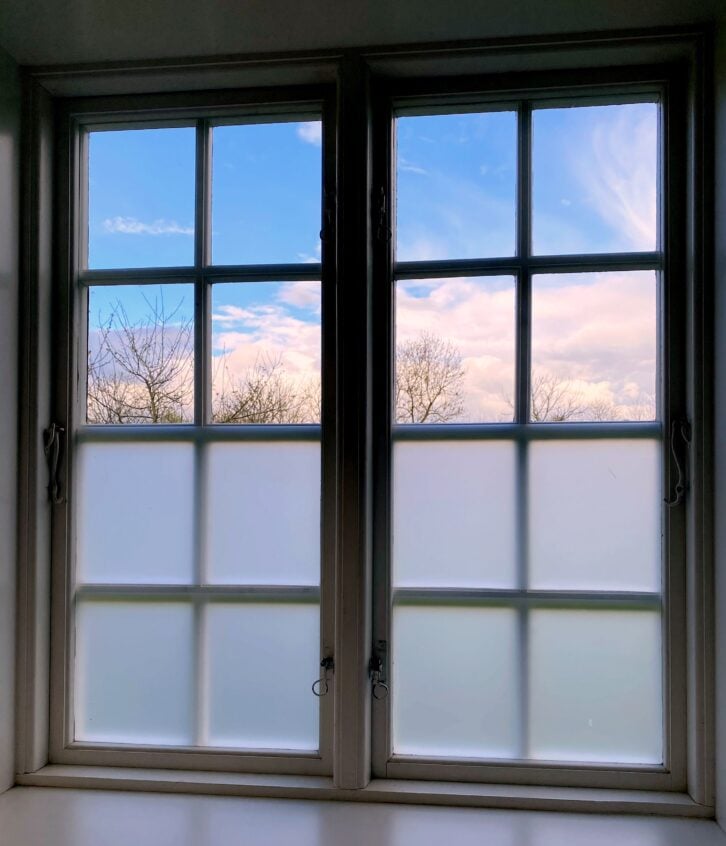 Bathroom designed with frosted glass windows for privacy.