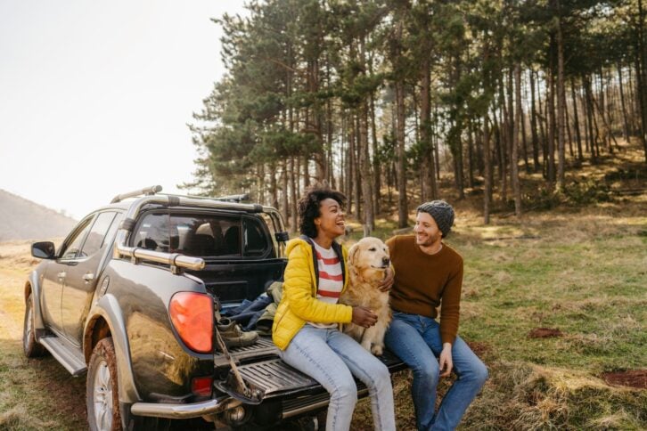 Photo of a couple on a road trip with their dog