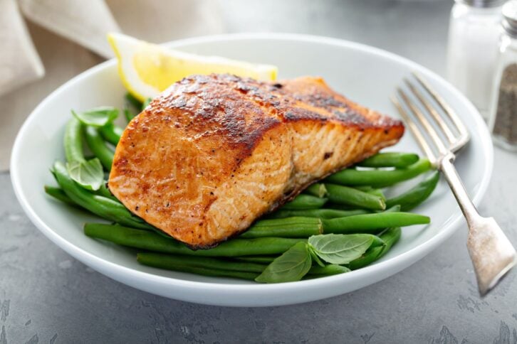 Grilled blackened salmon served with green beans and lemon