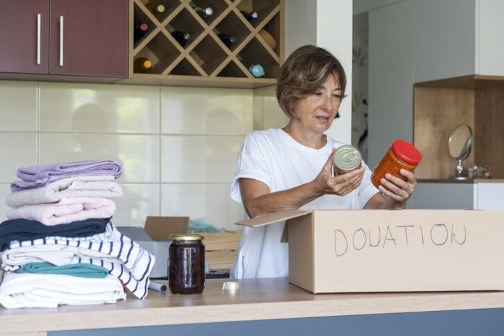 Senior woman preparing and packing donations at home.