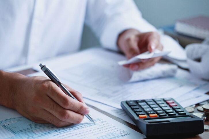 Man hand filling US tax form. tax form us business income office Financial document. Tax time.Tax concept. Close-up.