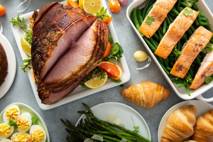 Easter brunch with spiral cut ham, asparagus and roasted salmon overhead shot