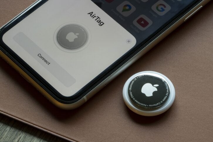 Portland, OR, USA - Sep 9, 2021: An AirTag is seen being connected to an iPhone. AirTag is a tracking device developed by Apple.