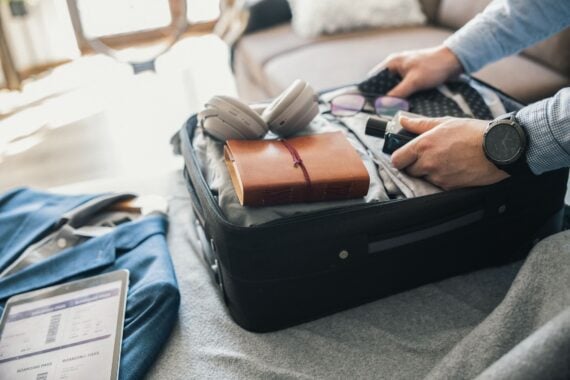 Unrecognisable man packing his suitcase for a business trip.