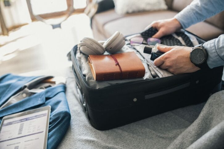Unrecognisable man packing his suitcase for a business trip.