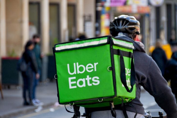 Cardiff, Wales - March 2022: Cycle courier for the Uber Eats food delivery service riding through the city centre