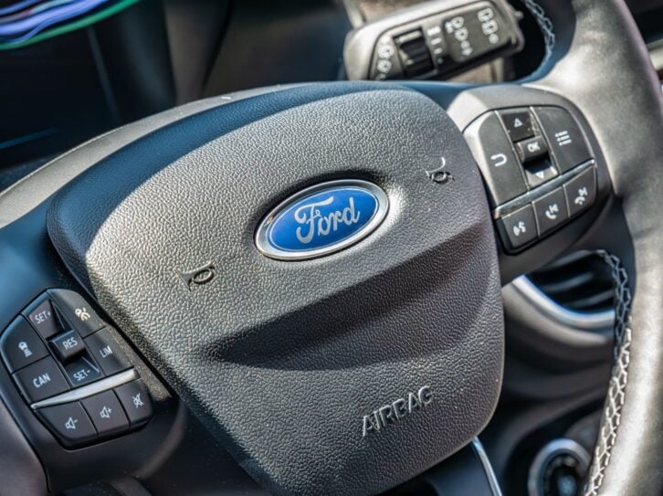 Close up detail with the logo of Ford company car on a steering wheel