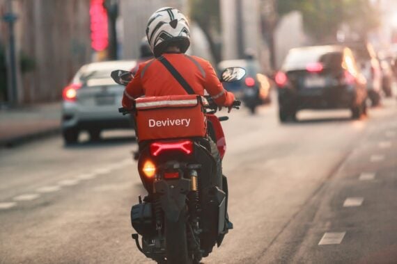 A food delivery driver is driving deliveries to customers ordering food online in a busy capital city, Impact of epidemics