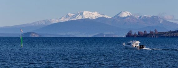 Boat at the lake Taupo, volcanoes at the background. New Zealand