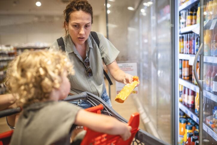 Photo of mother and her son at the supermarket buying groceries