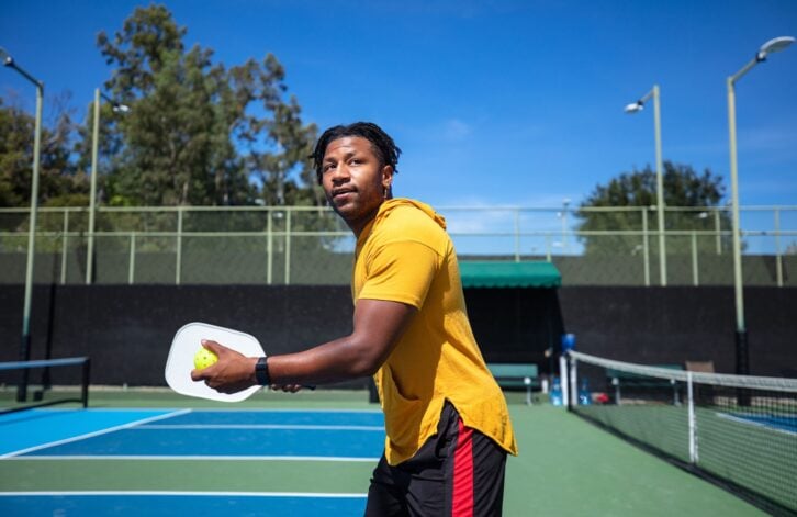 Portrait of a sporty Cape Verdean man in his 20s playing pickleball.