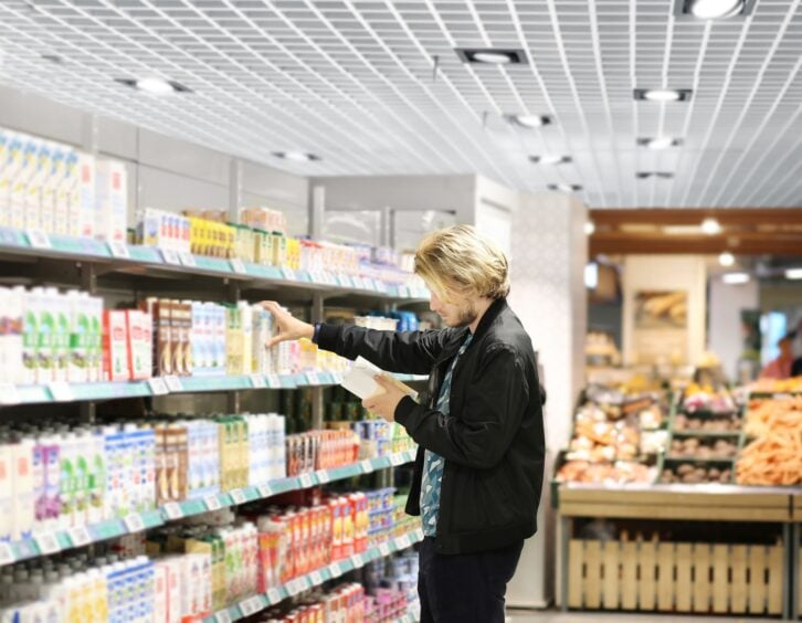 Man choosing frozen food from a supermarket freezer., reading product information