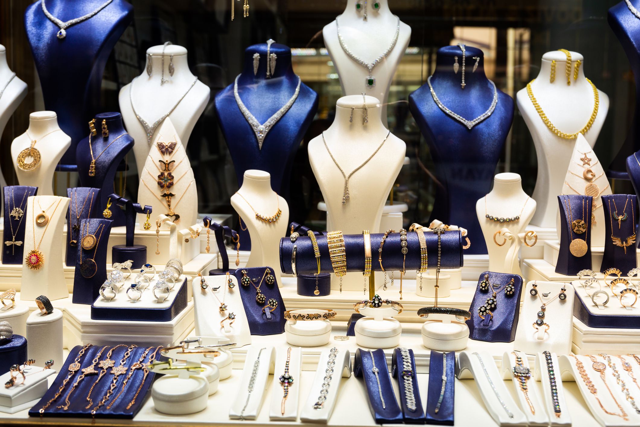 Contemporary gold and gemstone jewelry placed in showcase of jewellery store.