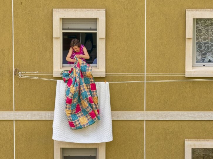 The Abruzzo region in Italy on May  30, 2022:  Elderly woman hanging laundry out of her apartment window in the Town of Scanno in the Abruzzo countryside of Italy