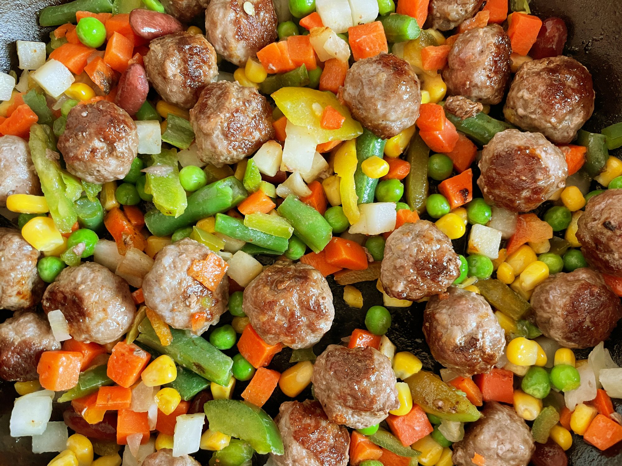 Homemade meatballs with fried vegetables, portion for lunch or dinner. Top view. This image was taken with a mobile phone.