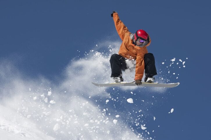 man in mid-air on snowboard