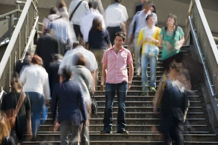 Young man stands out from the crowd shot with a daytime long exposure