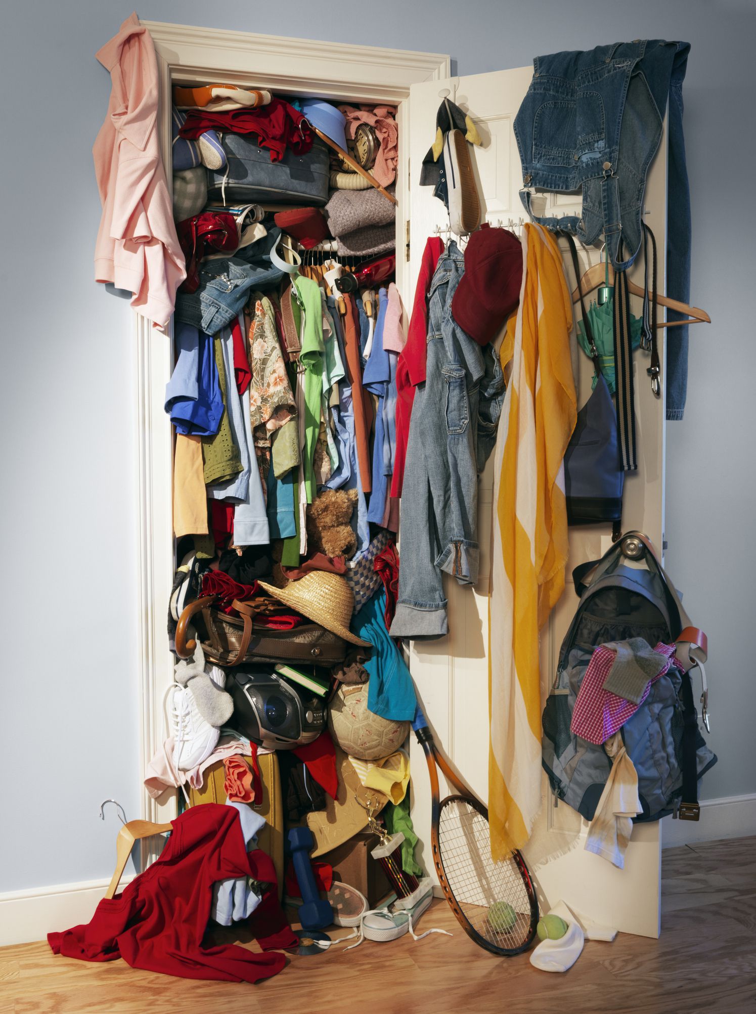A very messy, unorganized closet. Vertical shot.