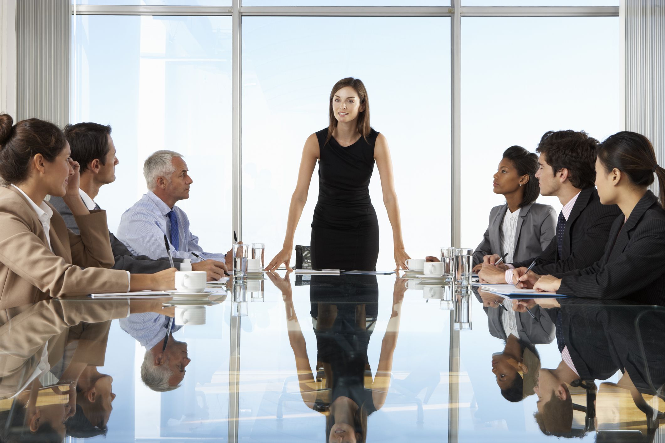 Group Of Business People Having Board Meeting Around Glass Table.