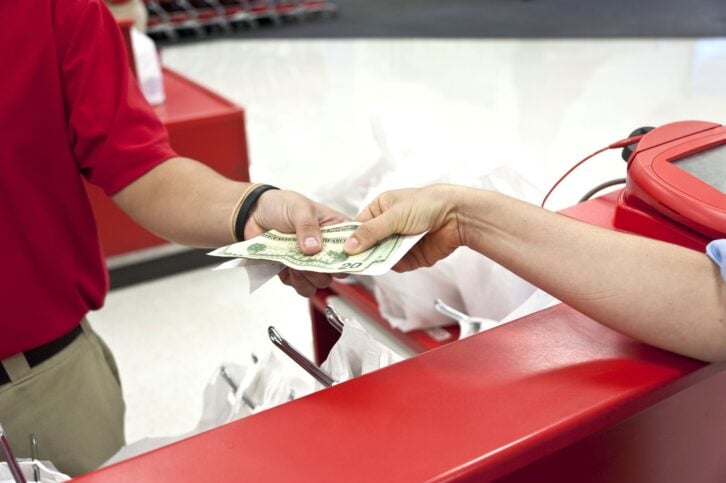 Woman receiving cash back when paying at a supermarket