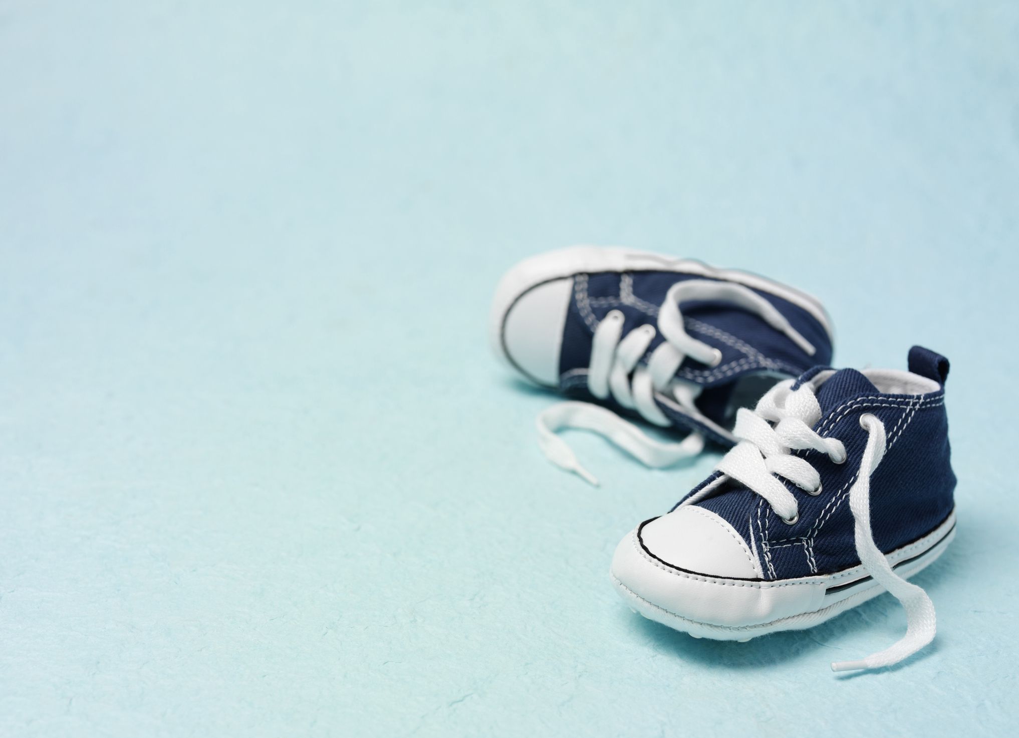 Blue canvas boots on a baby blue background.