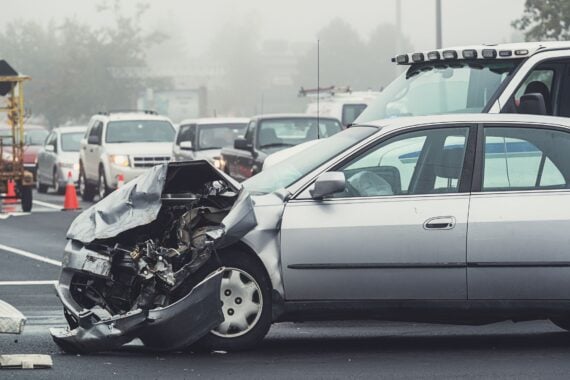 Heavy traffic backs up on the scene of an accident in foggy conditions.