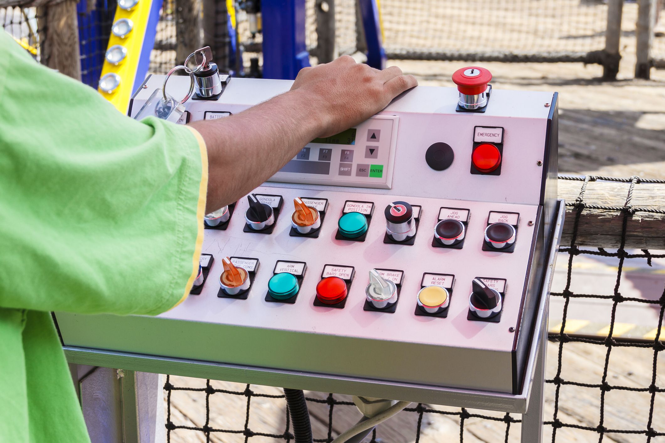 A close-up of the hands of carnival ride operator and his control board. A working hands photo.