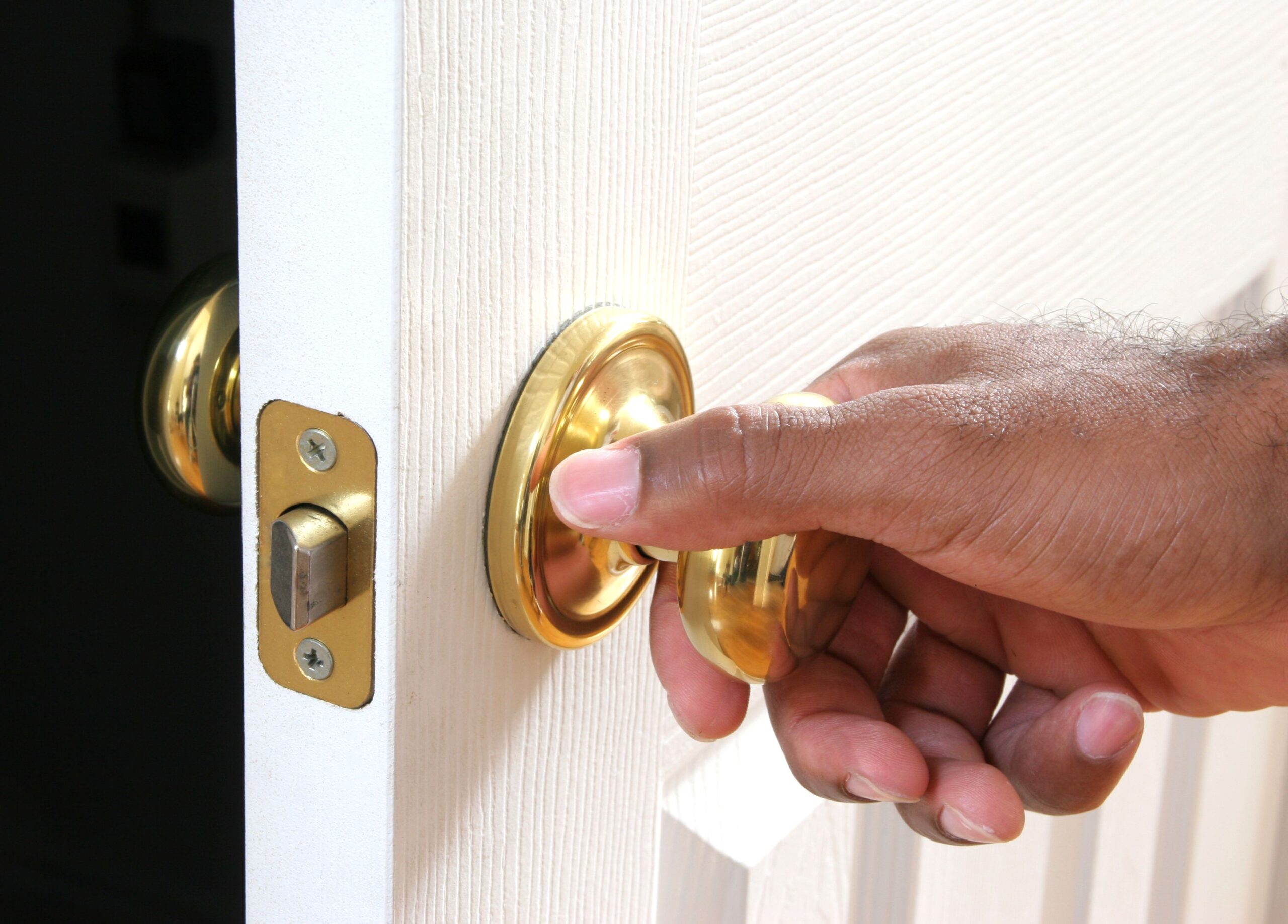 Ethnic hand opening door to mysterious dark room