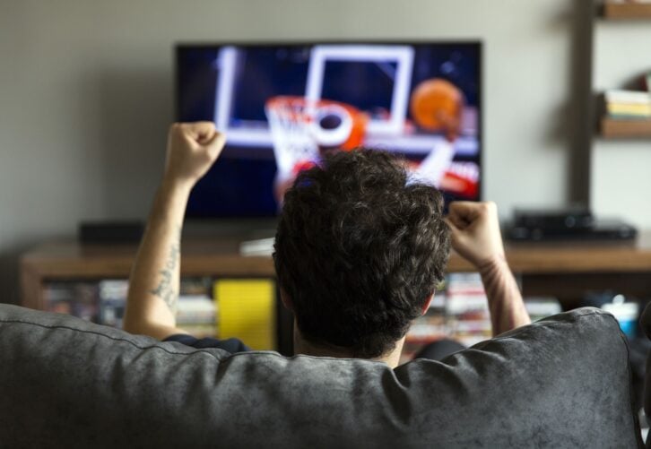 Man watching basketball game on tv and cheering