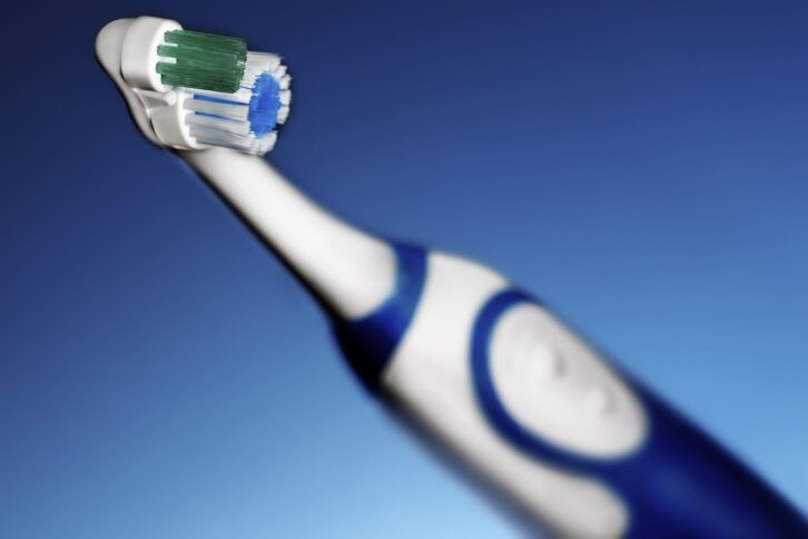 electric toothbrush against blue background