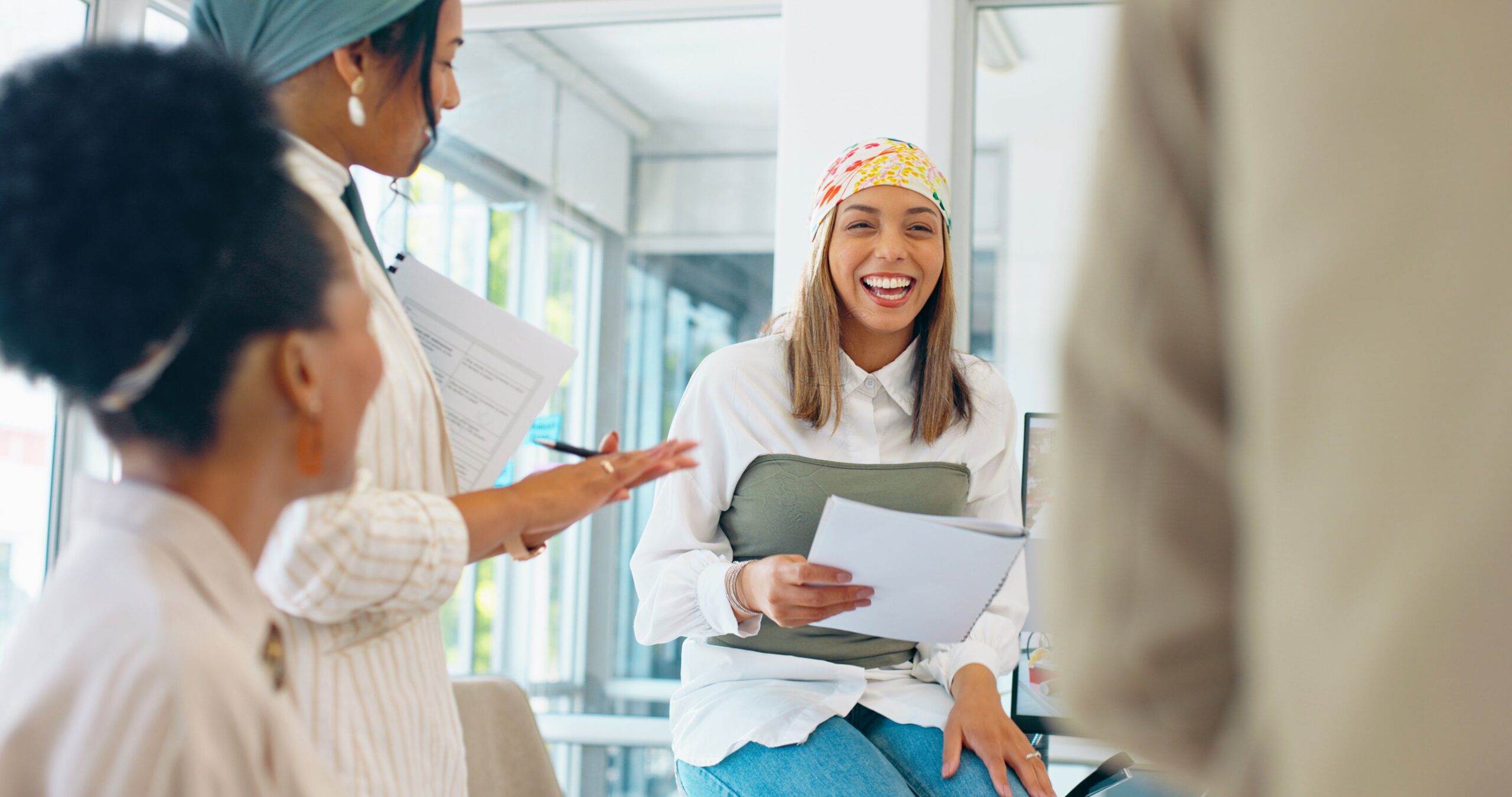 Business women, teamwork or diversity meeting on paper or documents review in coaching or training feedback. Smile, happy or talking speaker in leadership workshop, collaboration or strategy planning