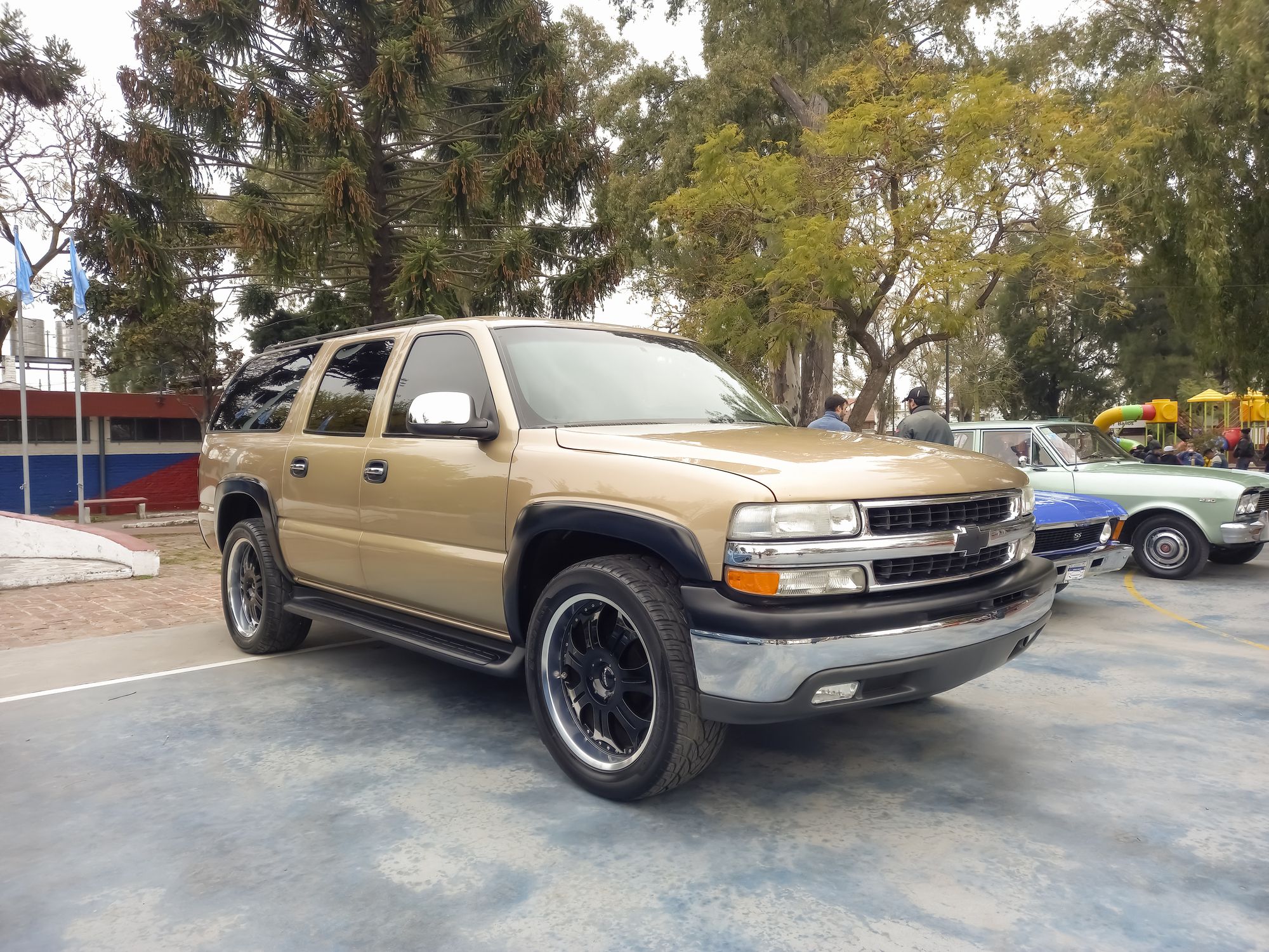 Lanús, Argentina - Sept 23, 2023: old beige Chevrolet Suburban full size SUV circa 2000 at a classic car show in a park.