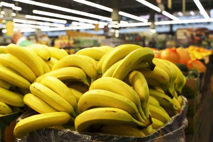 Bananas in supermarket on the counter. Farm bananas fruits and vegetables on sale in a store. High quality photo